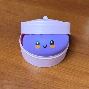 Purple Smiling Toy in Pink Container